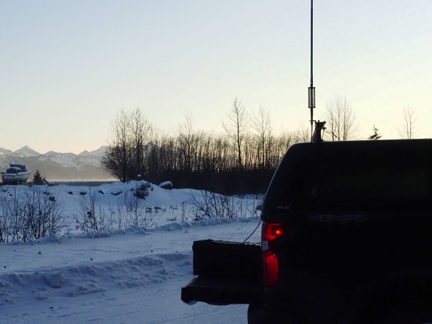 Antenna and truck in silhouette in winter